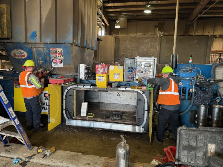 HMS technician performing two ram baler reline and repair service at customer recycling facility