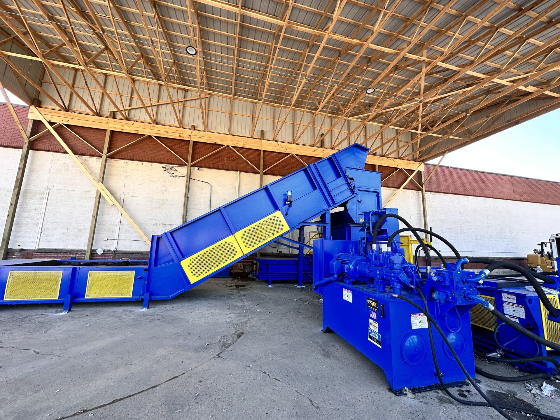 Conveyor infeed system feeding material into two-ram baler installed by Hoosier Machinery Solutions HMS Indiana