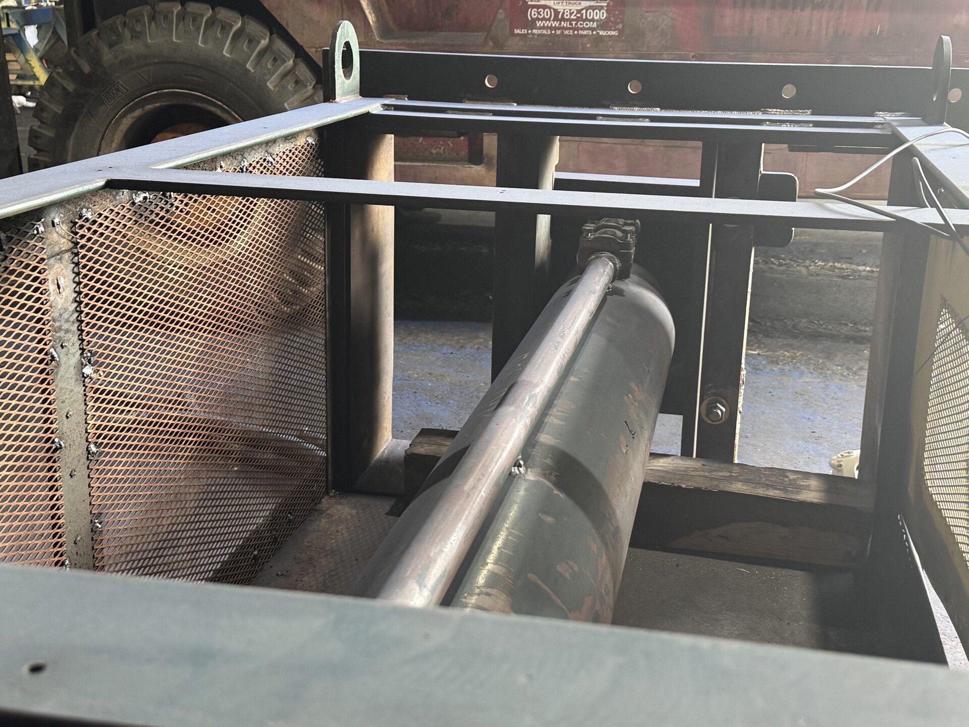 HMS technician inspecting two-ram baler hydraulic cylinder during reconditioning at Wanatah Indiana shop