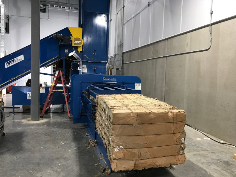 Horizontal auto-tie baler showing hopper infeed and bale ejection side for high volume OCC cardboard recycling