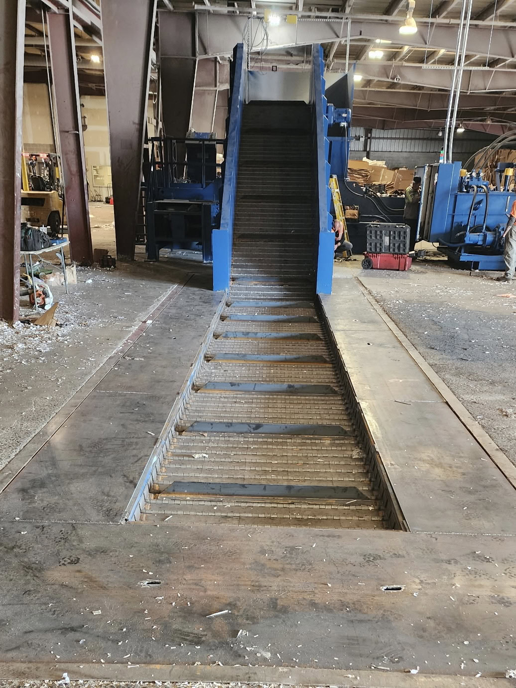 HMS baler infeed conveyor installation showing full conveyor run feeding material toward baler hopper