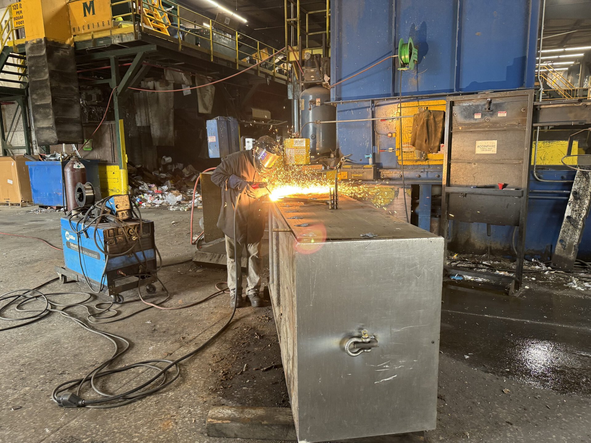 HMS technician performing a reline on an IBC two-ram baler on-site at customer facility